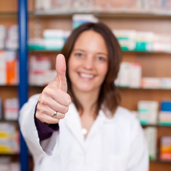 Säker kvinnliga farmaceut visar tummen upp tecken — Stockfoto