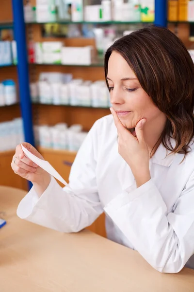 Thinking Woman Looking at Prescription — стоковое фото