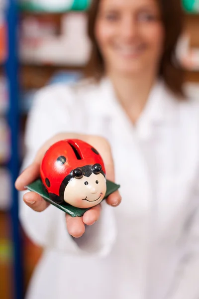 Farmacista Holding Ladybird a forma di Coinbank — Foto Stock