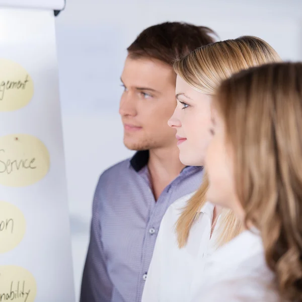 Geschäftsleute schauen auf Flipchart — Stockfoto