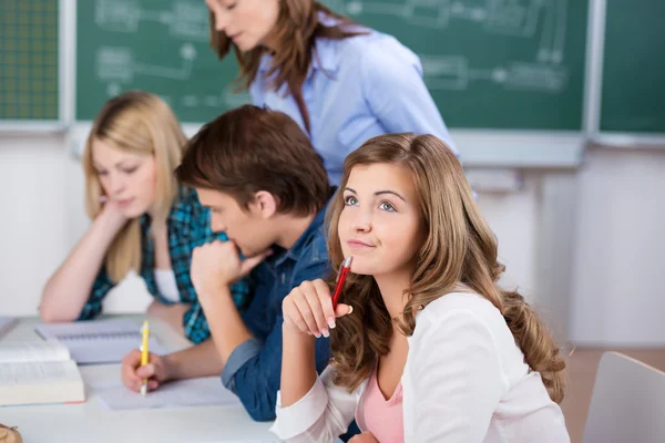 Blonde Studentin mit Kommilitonen am Schreibtisch — Stockfoto