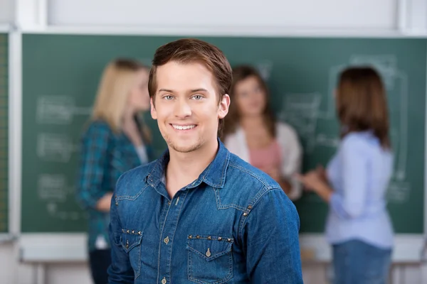 Schüler lächelt mit Lehrer und Klassenkameraden im Hintergrund — Stockfoto