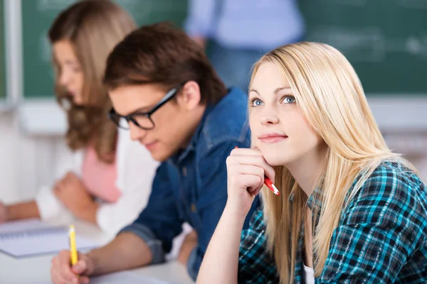 Thinking Female Student Sitting With Classmates Royalty Free Stock Photos