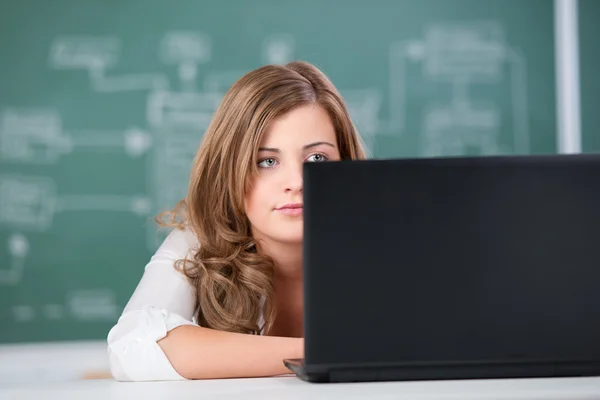 Estudante do sexo feminino usando laptop contra papelão — Fotografia de Stock