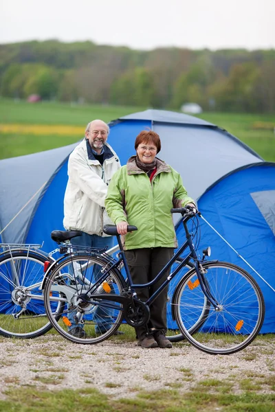 Casal com bicicletas em pé contra tenda — Fotografia de Stock