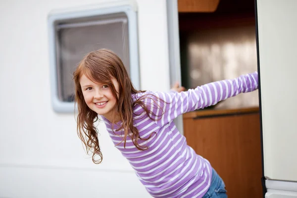 Fille souriante debout à l'entrée de la caravane — Photo