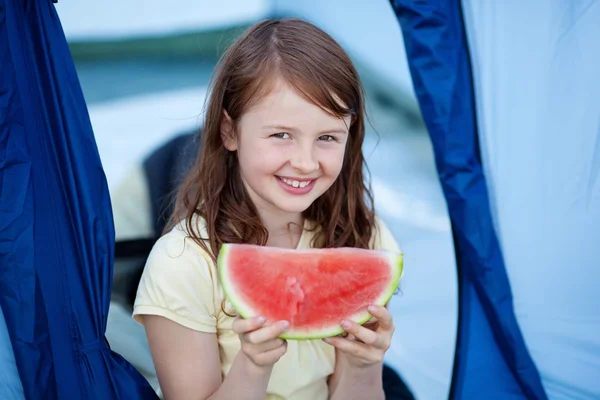 Meisje segment van watermeloen houden tegen tent — Stockfoto