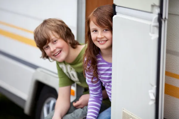 Två barn sitter i dörren av rv — Stockfoto