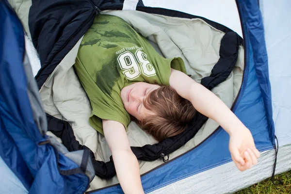 Молодой уставший мальчик спит в палатке — стоковое фото