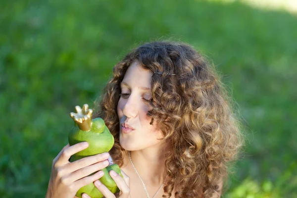 Chica besos juguete rana en parque — Foto de Stock