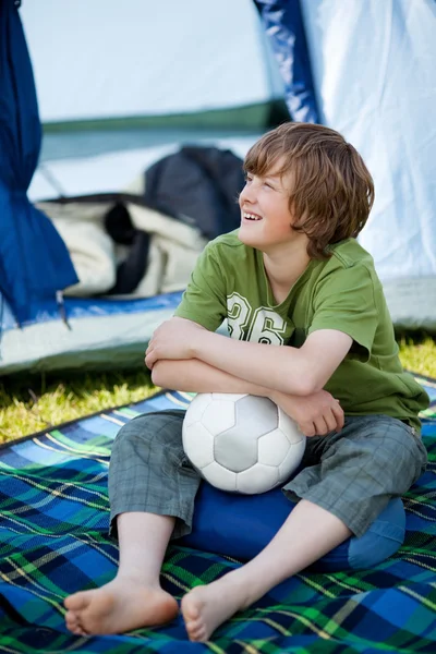 Niño sosteniendo balón de fútbol en frente de la tienda — Foto de Stock