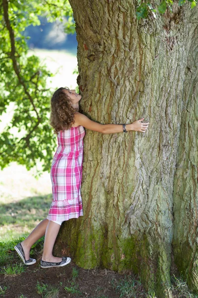 Adolescente menina abraçando árvore — Fotografia de Stock