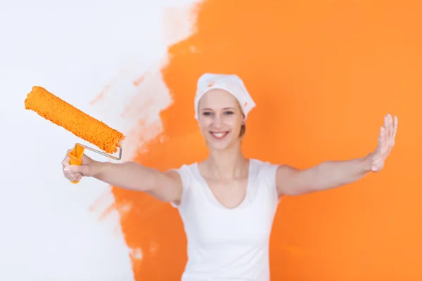 Mujer feliz pintando casa en naranja — Foto de Stock