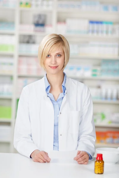 Farmacêutico com garrafa de pílula e papel de prescrição — Fotografia de Stock