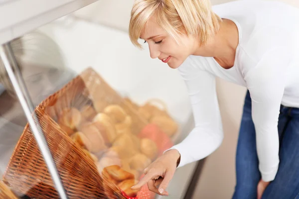 Klant kiezen brood uit vitrinekast in café — Stockfoto