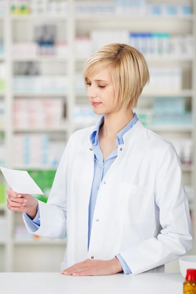 Farmacista donna guardando prescrizione medica — Foto Stock