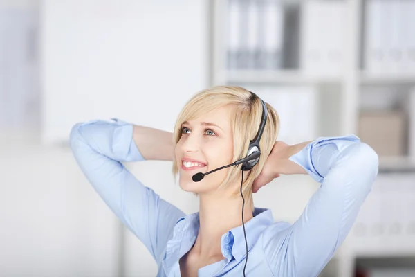 Relaxed businesswoman wearing headset — Stock Photo, Image