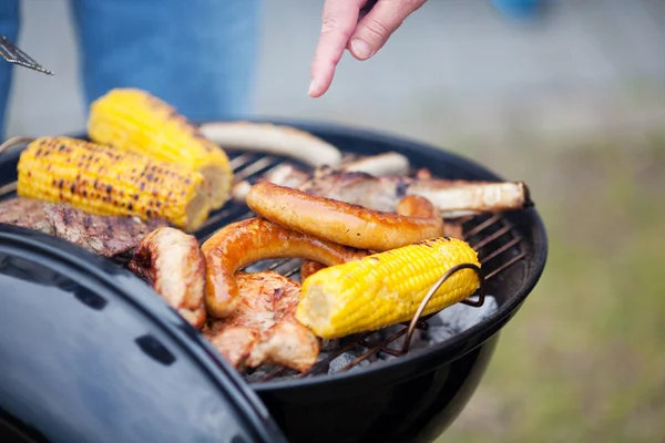 Ręka, grillowanie mięsa i kukurydzy — Zdjęcie stockowe