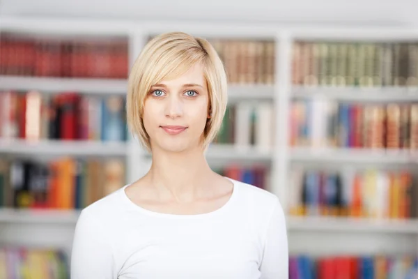 Blonďatá žena, která stála v knihovně — Stock fotografie