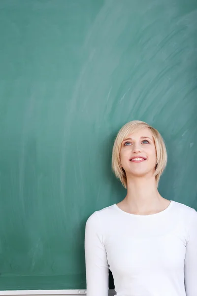 Vrouwelijke student leunend op schoolbord — Stockfoto