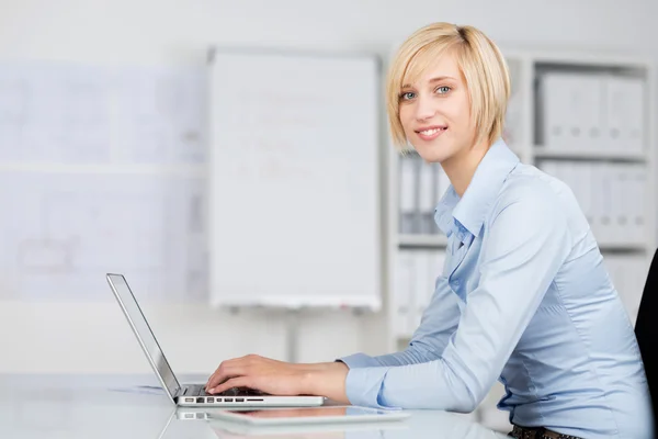 Молодая деловая женщина, использующая ноутбук в офисе — стоковое фото