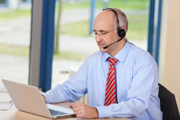 Customer Service Executive Wearing Headset While Using Laptop — Stock Photo, Image