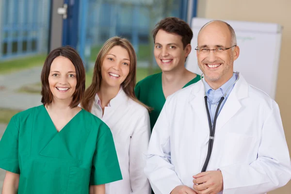 Equipe de médico feliz em pé juntos na clínica — Fotografia de Stock