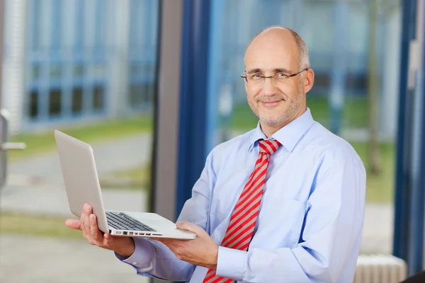 Empresário maduro com laptop — Fotografia de Stock