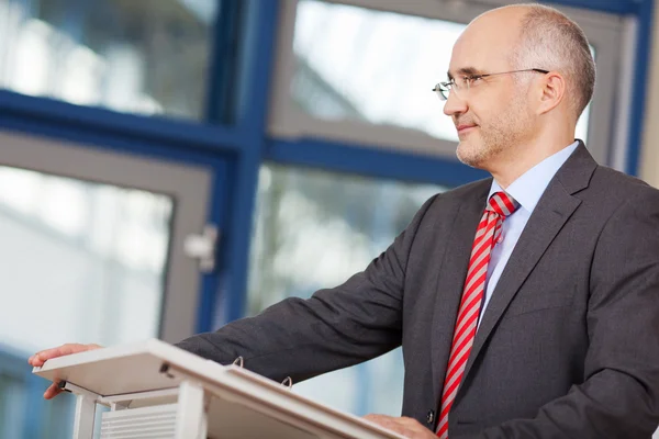 Zakenman op zoek weg terwijl staande op podium — Stockfoto