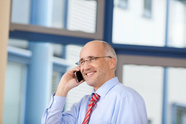 Homme d'affaires utilisant un téléphone portable au bureau — Photo