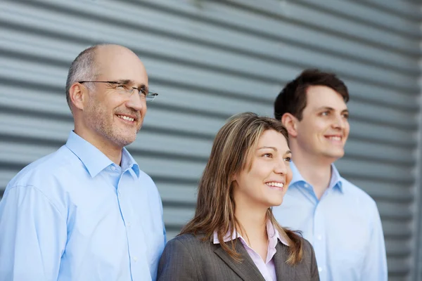 Empresarios mirando hacia otro lado contra obturador — Foto de Stock