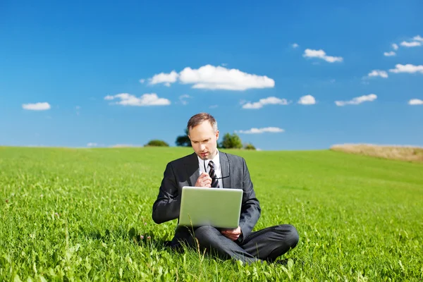 Podnikatel sedí venku myšlení — Stock fotografie