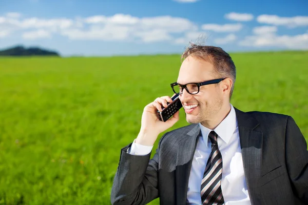 Businessman using his mobile in the countryside — Stock Photo, Image