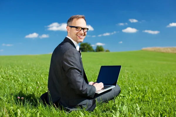 Zakenman buitenshuis werken onder een blauwe lucht — Stockfoto