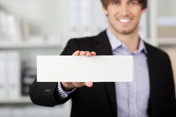 Empresario sosteniendo papel en blanco en la oficina — Foto de Stock