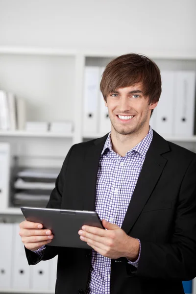 Empresario sosteniendo tableta digital en la oficina — Foto de Stock