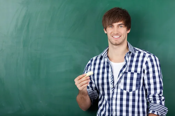 Jovem estudante do sexo masculino na frente de Chalkboard — Fotografia de Stock