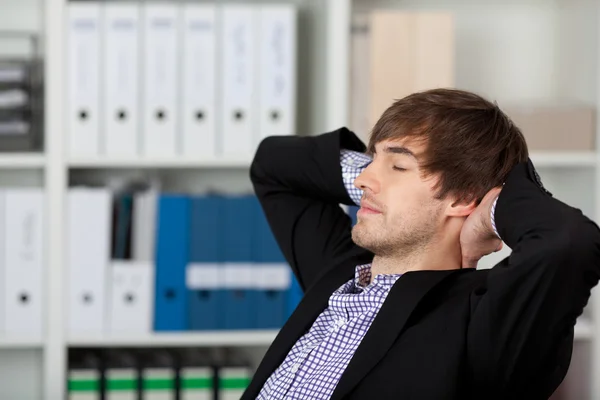 Empresario con las manos detrás de la cabeza y los ojos cerrados —  Fotos de Stock