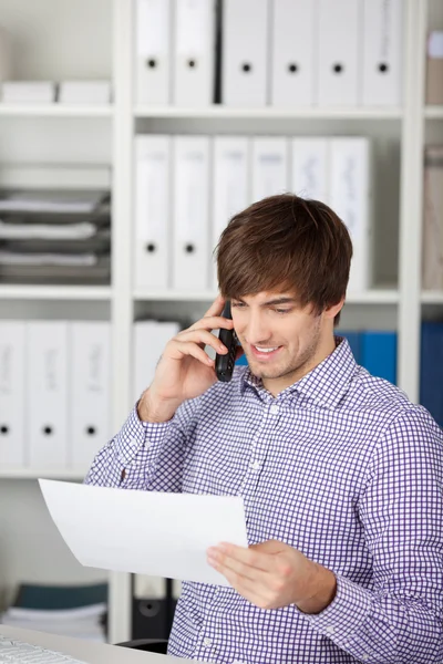 Ung affärsman med telefonen i office — Stockfoto