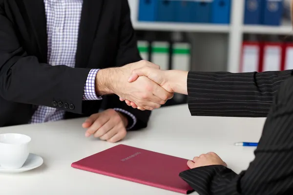Businesspeople Shaking Hands At Office Desk — Stock Photo, Image
