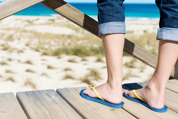 Kvinna med flip-flops tittar på havet — Stockfoto