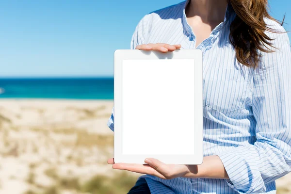 Woman showing white paper by the beach — Stock Photo, Image
