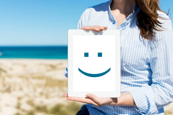 Woman Displaying Digital Tablet With Smiley Face At Beach — Stock Photo, Image