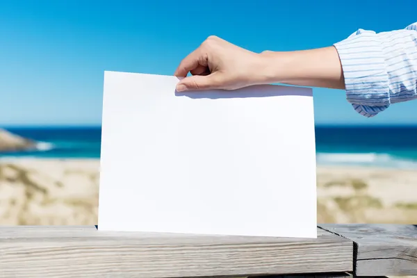 Womans Hand Holding Blank Placard At Beach — Stock Photo, Image