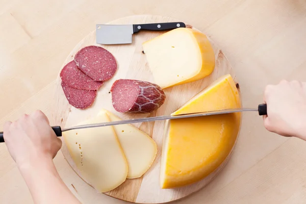 Cutting cheese and sausage — Stock Photo, Image