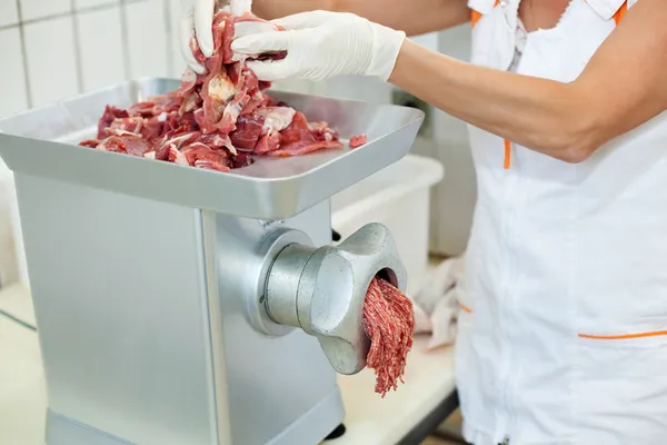 Een man die vlees hakken — Stockfoto