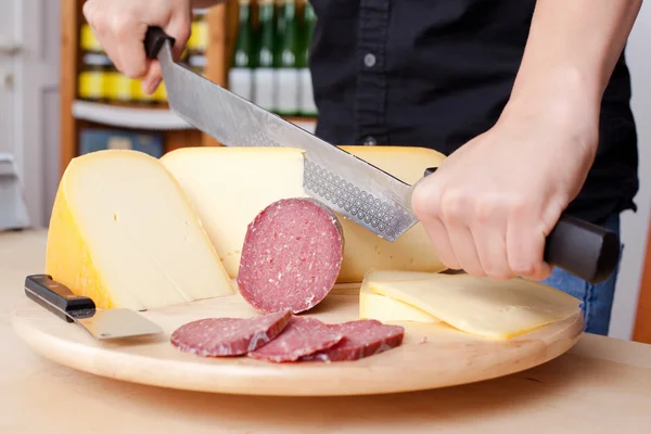 Cutting sausage and cheese — Stock Photo, Image