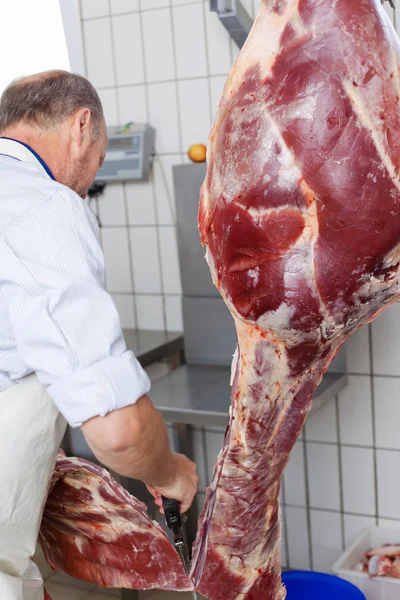 Butcher cutting the cow into two — Stock Photo, Image