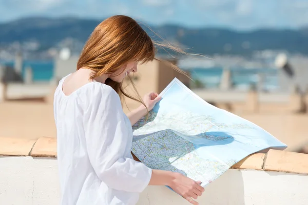 Vrouw raadpleging van een kaart op een stedelijke op het dak — Stockfoto