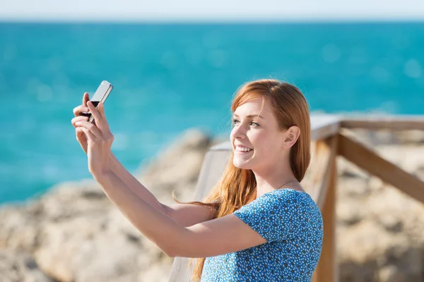 Mujer fotografiándose con un móvil — Foto de Stock